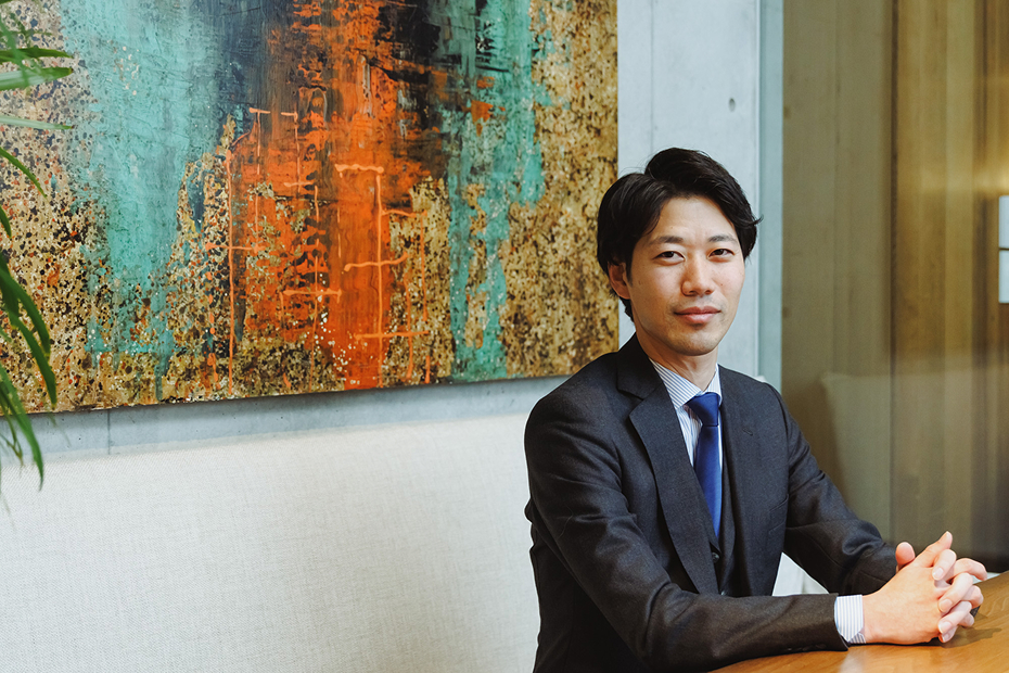 ネイビースーツの男性が笑顔で話す様子